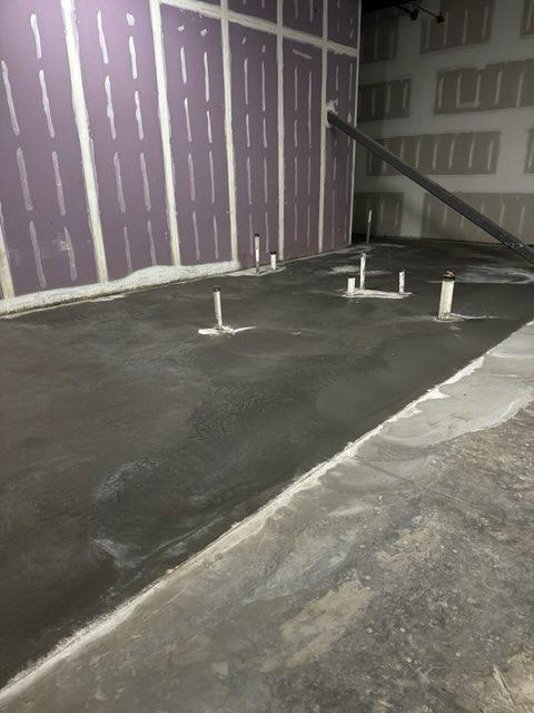 Pipes coming out of newly poured interior concrete slab